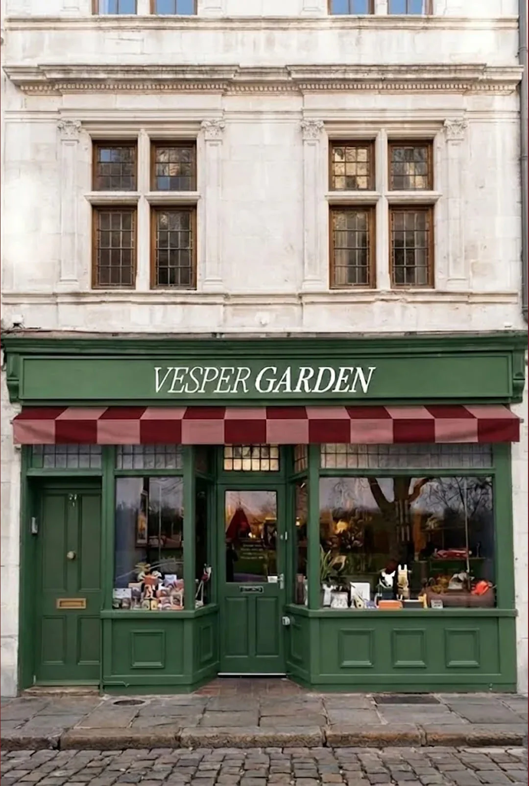 Devanture verte du concept store canin The Vesper Garden à Lyon, store rayé bordeaux et enseigne peinte